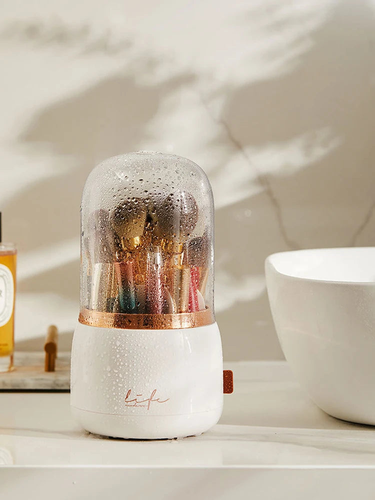 Closed white 360° Rotating Makeup Brush Storage Box with clear top, rose gold band and side handle