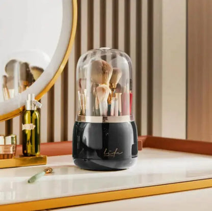 Black 360° Rotating Makeup Brush Storage Box with brushes under a transparent dome beside a mirror