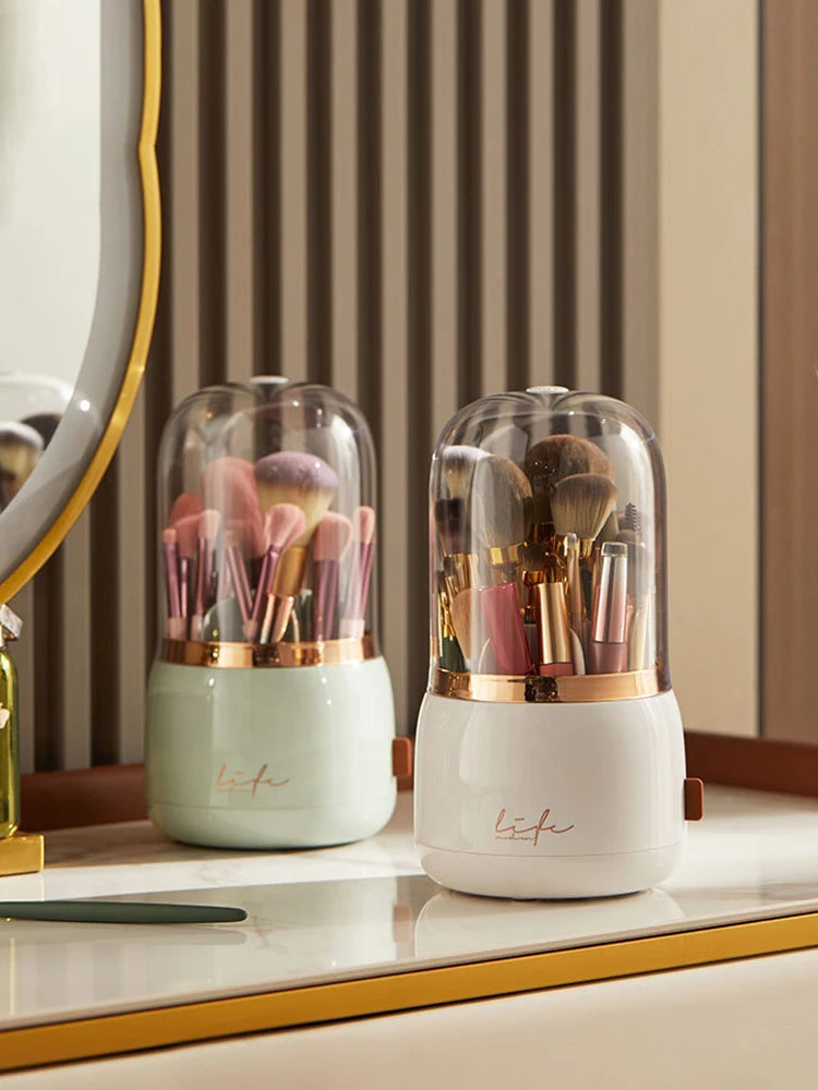 White 360° Rotating Makeup Brush Storage Box with brushes and clear dome in front of a mirror