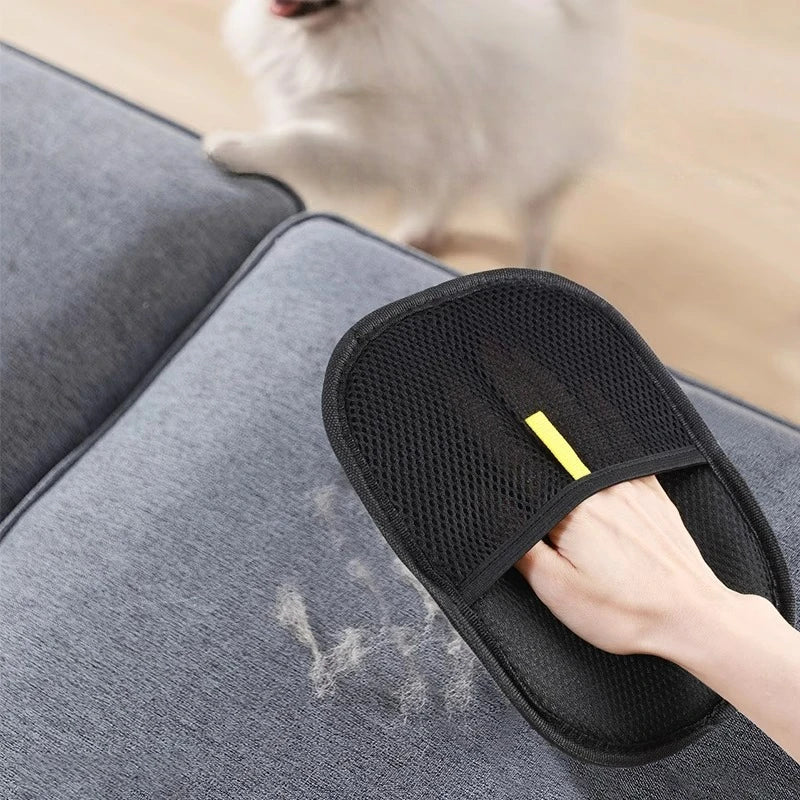 Black Pet Grooming Glove with yellow strip cleaning pet hair from gray fabric