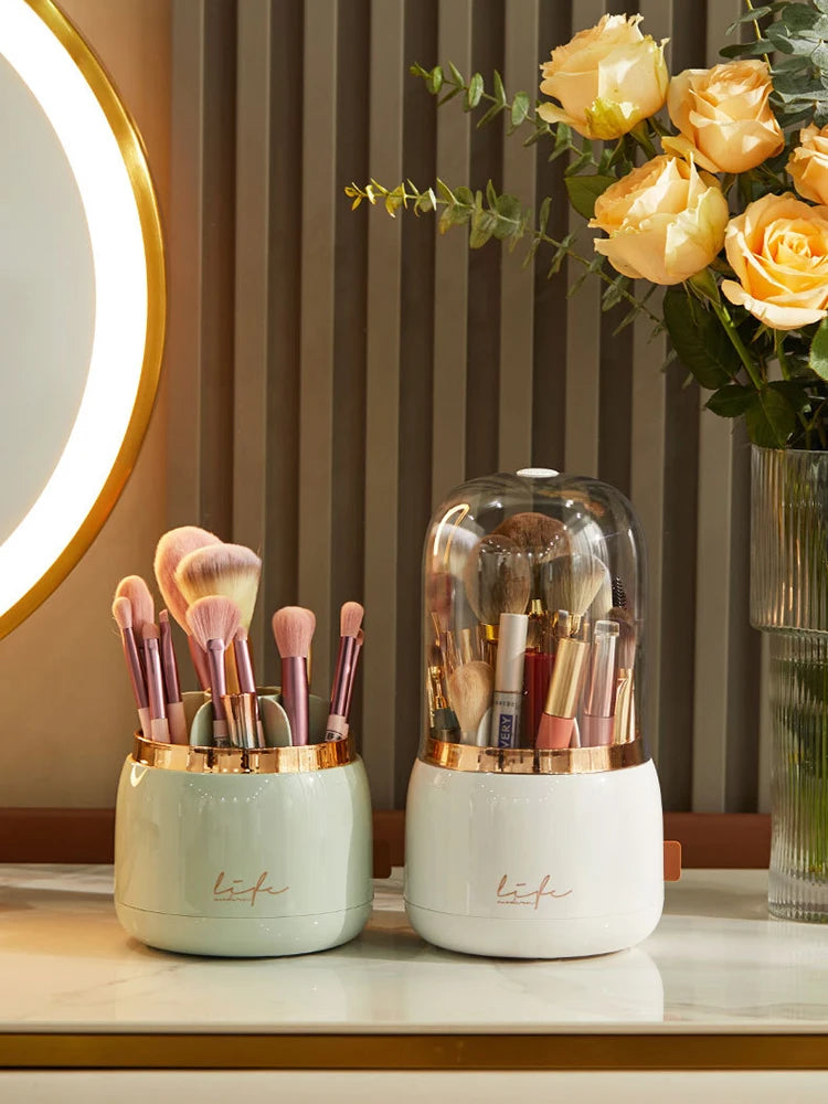 White 360° Rotating Makeup Brush Storage Box filled with brushes beside a mirror and yellow roses